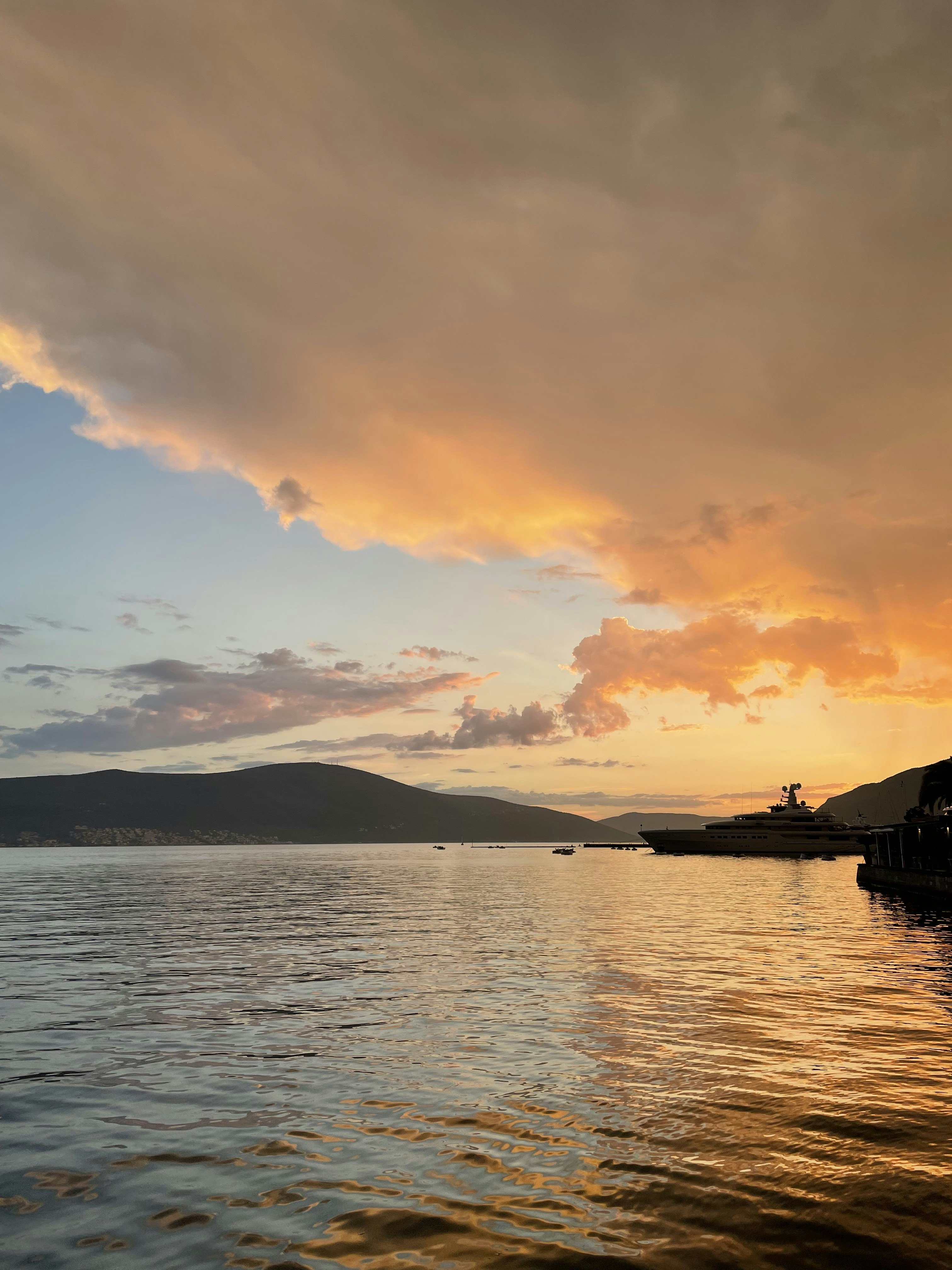 Luxury superyacht at anchor in a calm bay at sunset with golden light