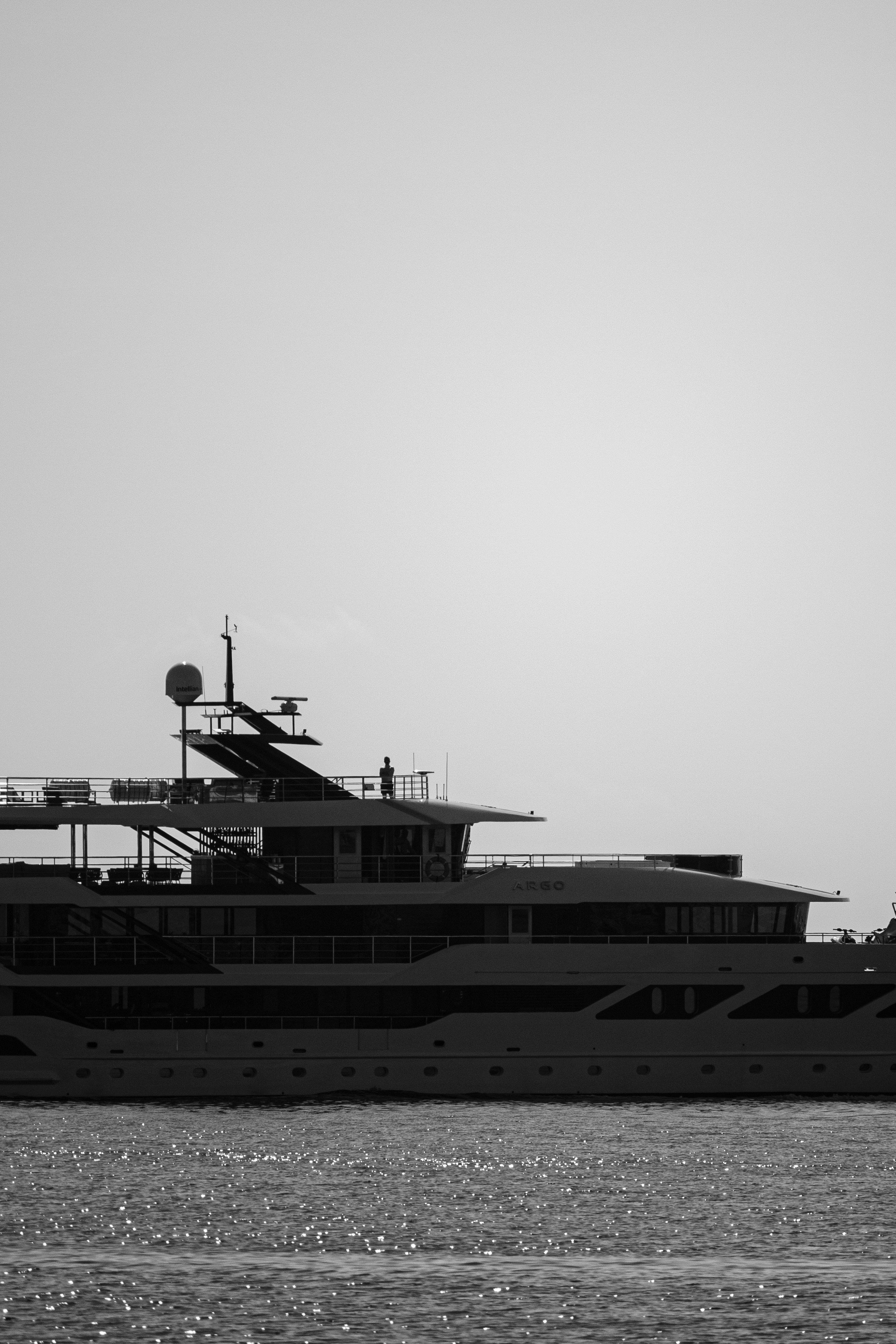 Superyacht crew member standing on deck looking out at the ocean during a quiet moment